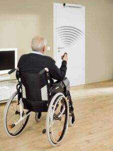 man in wheelchair opening door with remote control 