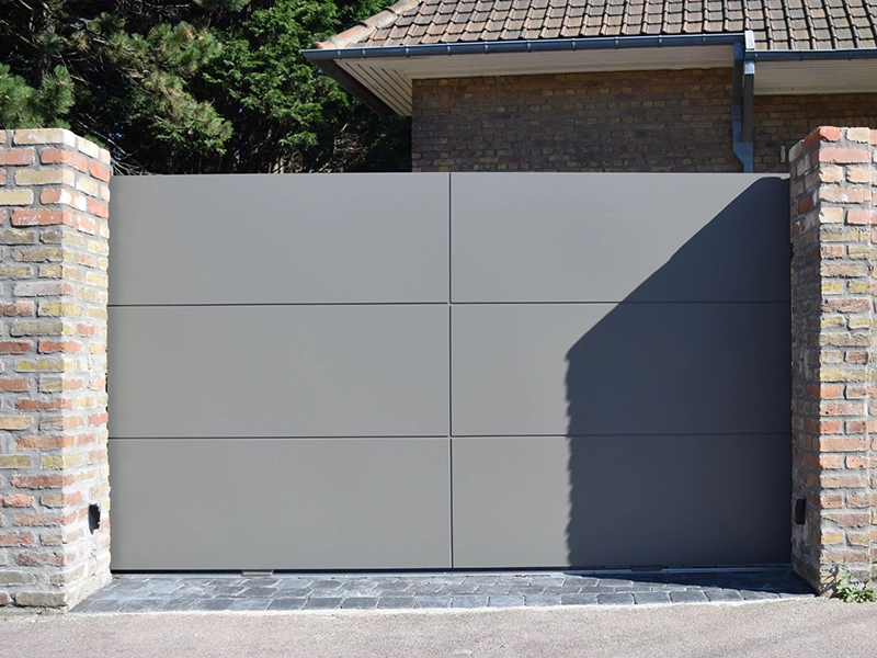A modern aluminium gate style with multi-panel design in a modern rustic setting.